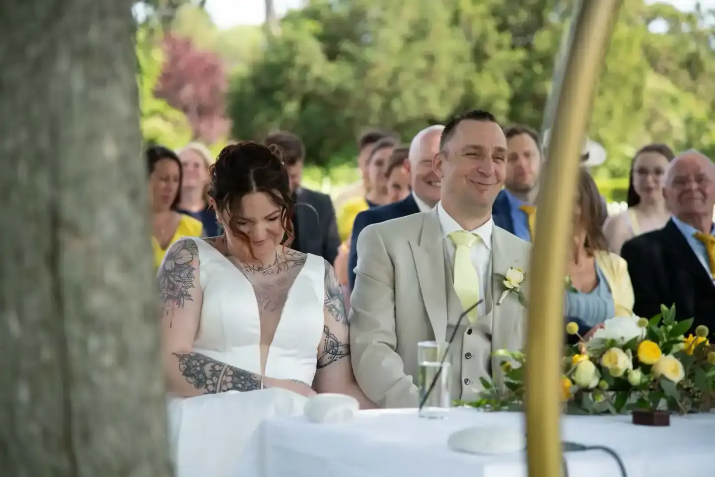 Brautpaar bei der Trauung unter freiem Himmel, Hochzeitsfotografie Wien mit Gästen im Hintergrund