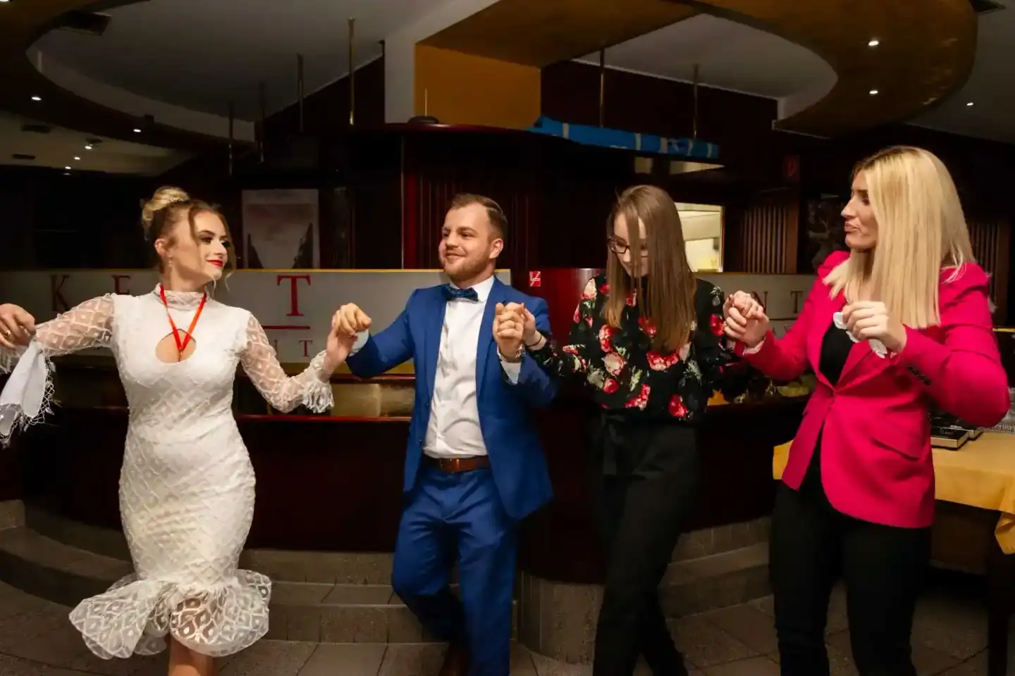 Brautpaar und Gäste tanzen fröhlich in einem modernen Hochzeitssaal – professionelle Hochzeitsfotografie Wien