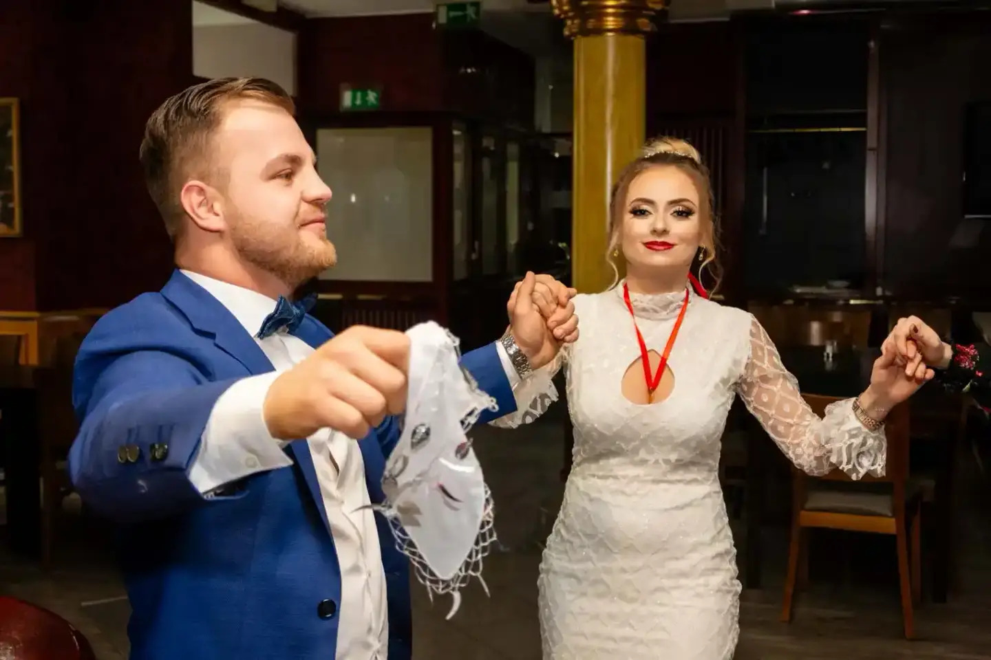 Brautpaar tanzt auf der Hochzeitsfeier in Wien – Bräutigam im blauen Anzug und Braut im weißen Spitzenkleid