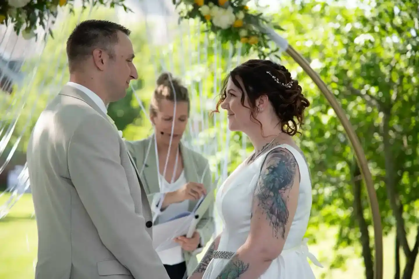 Brautpaar tauscht Eheringe unter grüner Laube aus – Hochzeitsfotograf Wien dokumentiert emotionalen Moment