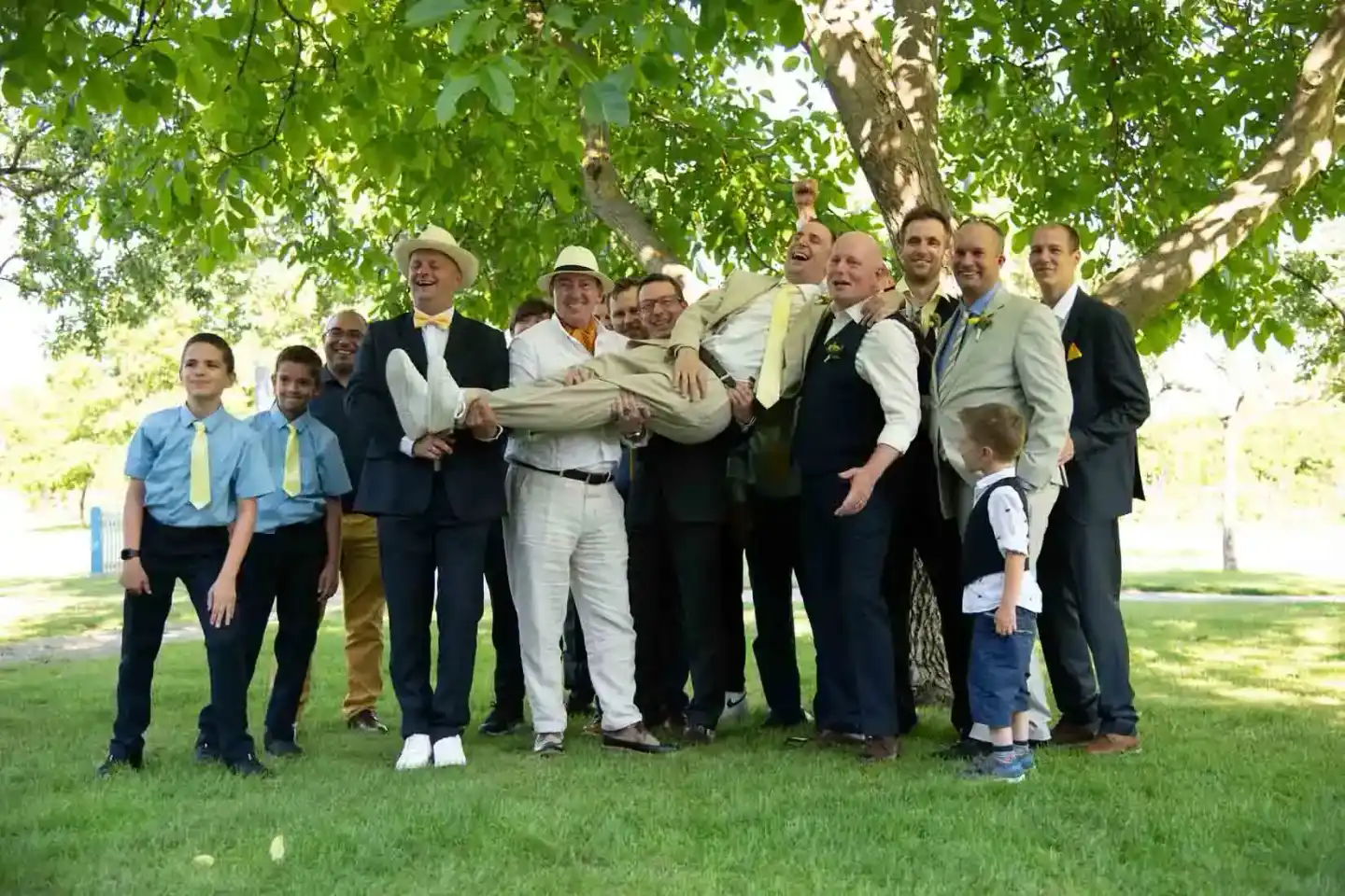 Hochzeitsgruppe mit Bräutigam und Gästen unter einem Baum - professionelle Hochzeitsfotografie Wien