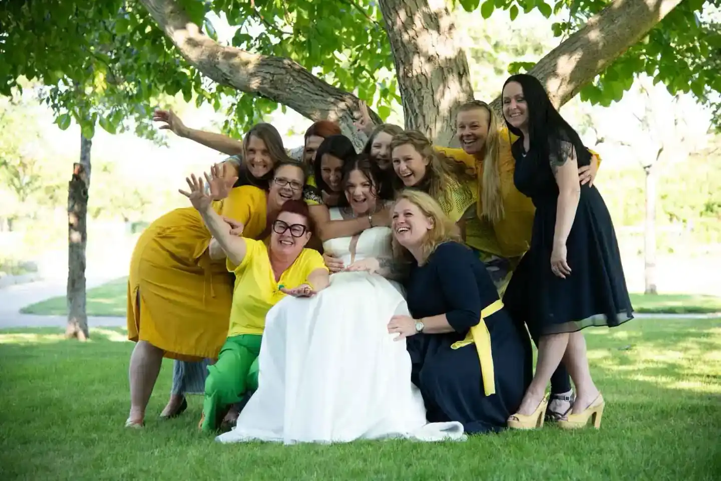 Brautjungfern und Braut in Weiß unter einem großen Baum, Hochzeitsfotografie Wien, fröhliche Gruppenaufnahme