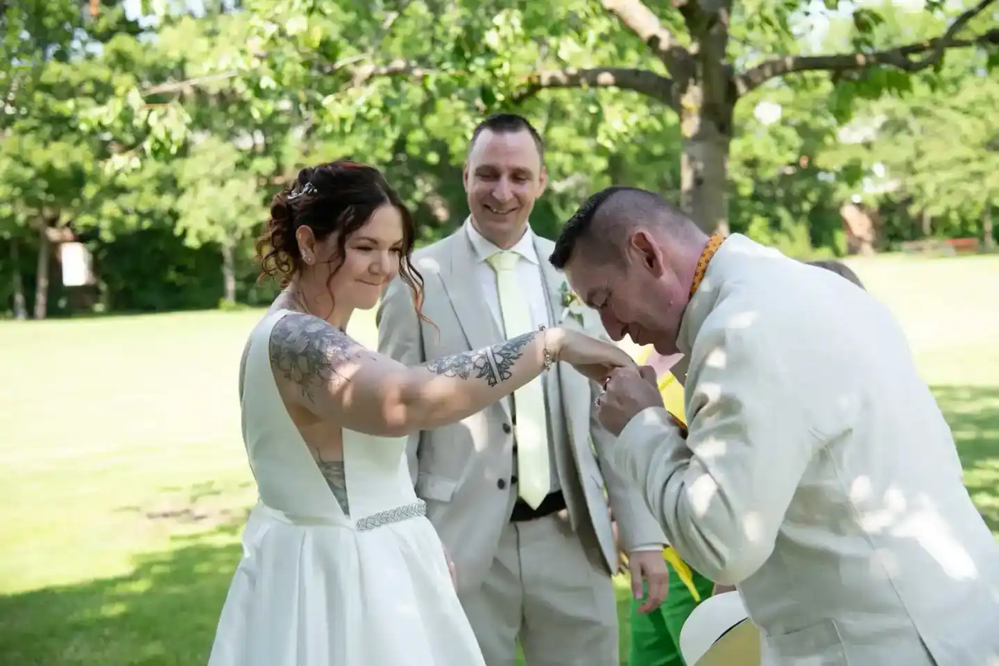Brautpaar beim Ringtausch mit Trauzeuge im Park – Hochzeitsfotografie Wien
